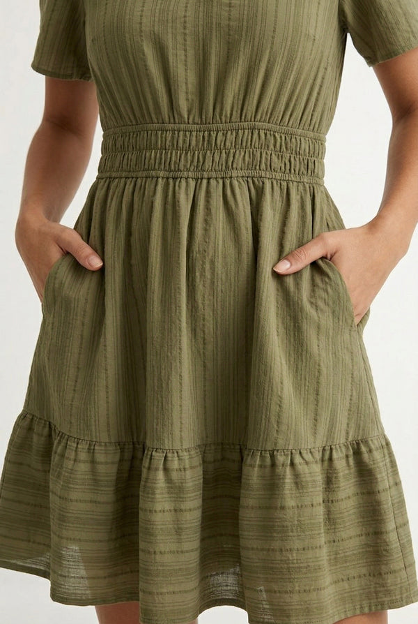 Woman wearing a short sleeve v-neck tiered dress in dark olive green