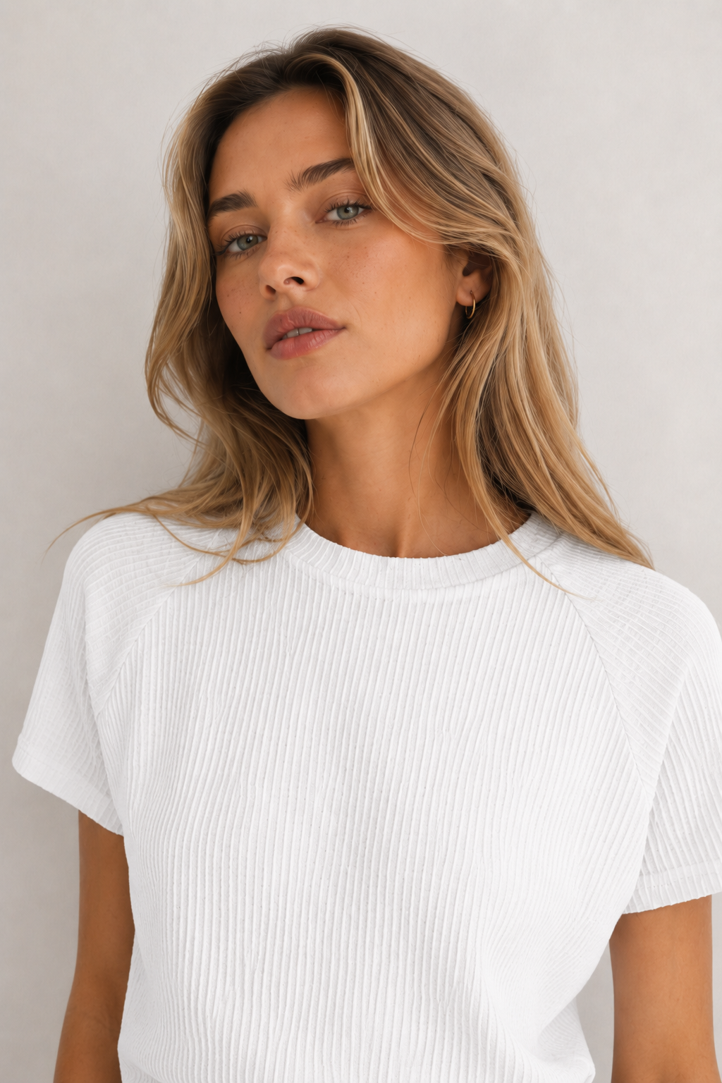 Woman wearing a blanc white short sleeve top and matching mini skirt lounge set.