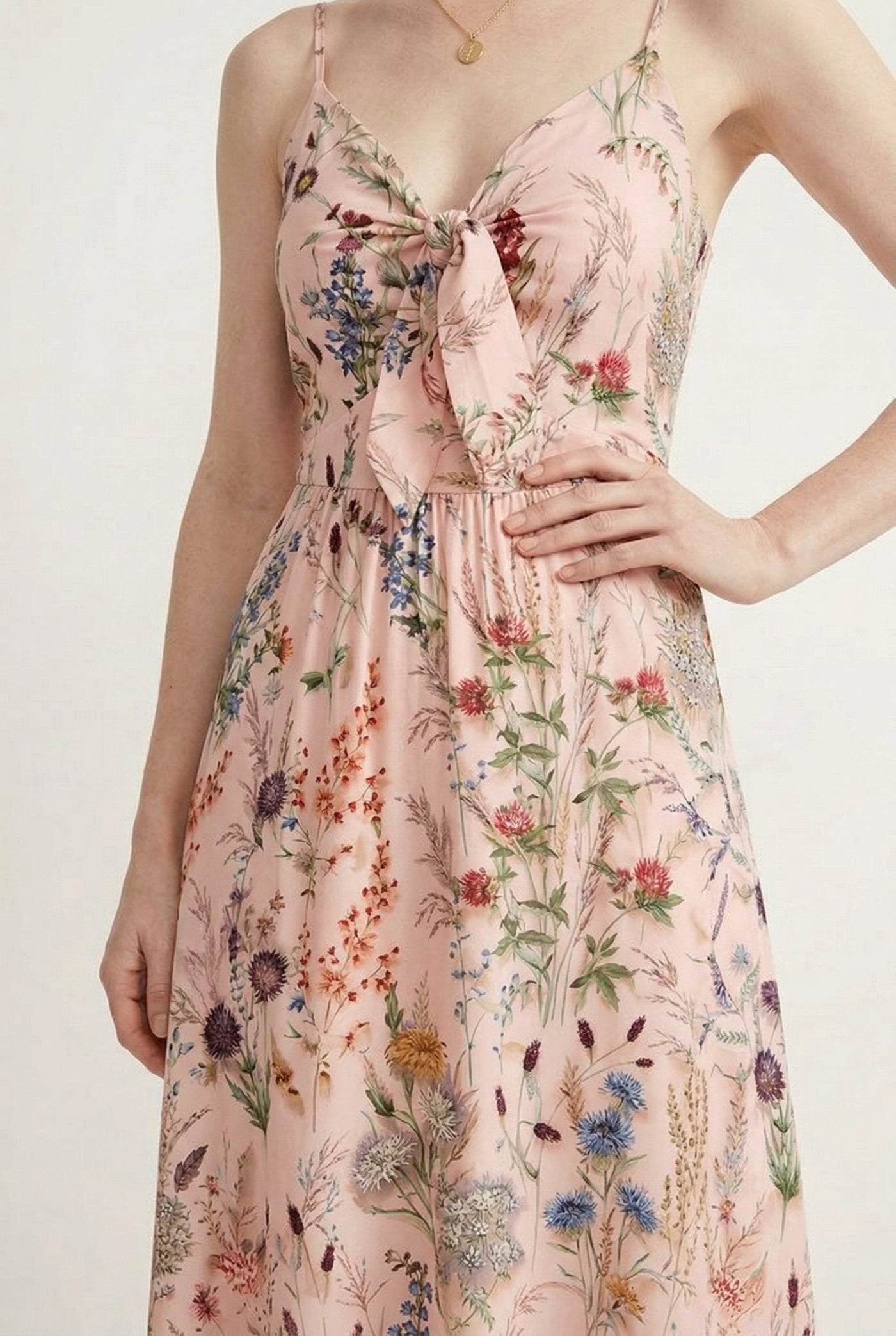 Woman wearing a rosewater pink floral print maxi dress with spaghetti straps