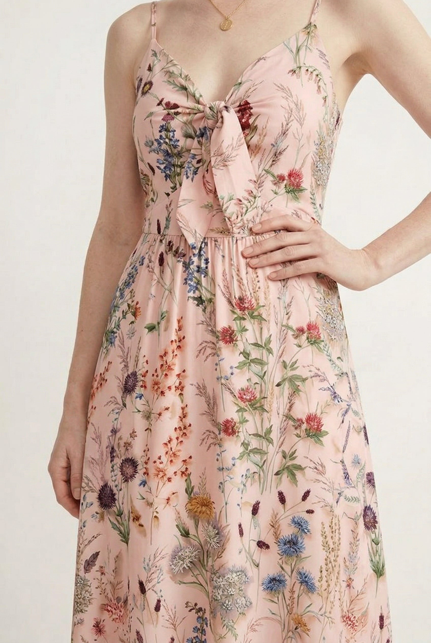 Woman wearing a rosewater pink floral print maxi dress with spaghetti straps
