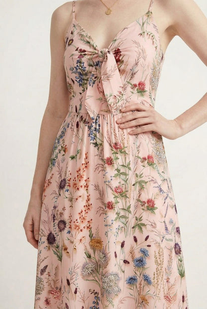 Woman wearing a rosewater pink floral print maxi dress with spaghetti straps