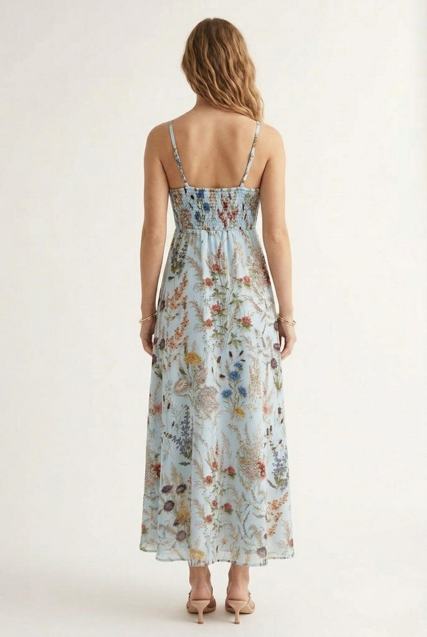 Woman wearing a chambray blue floral print maxi dress with spaghetti straps