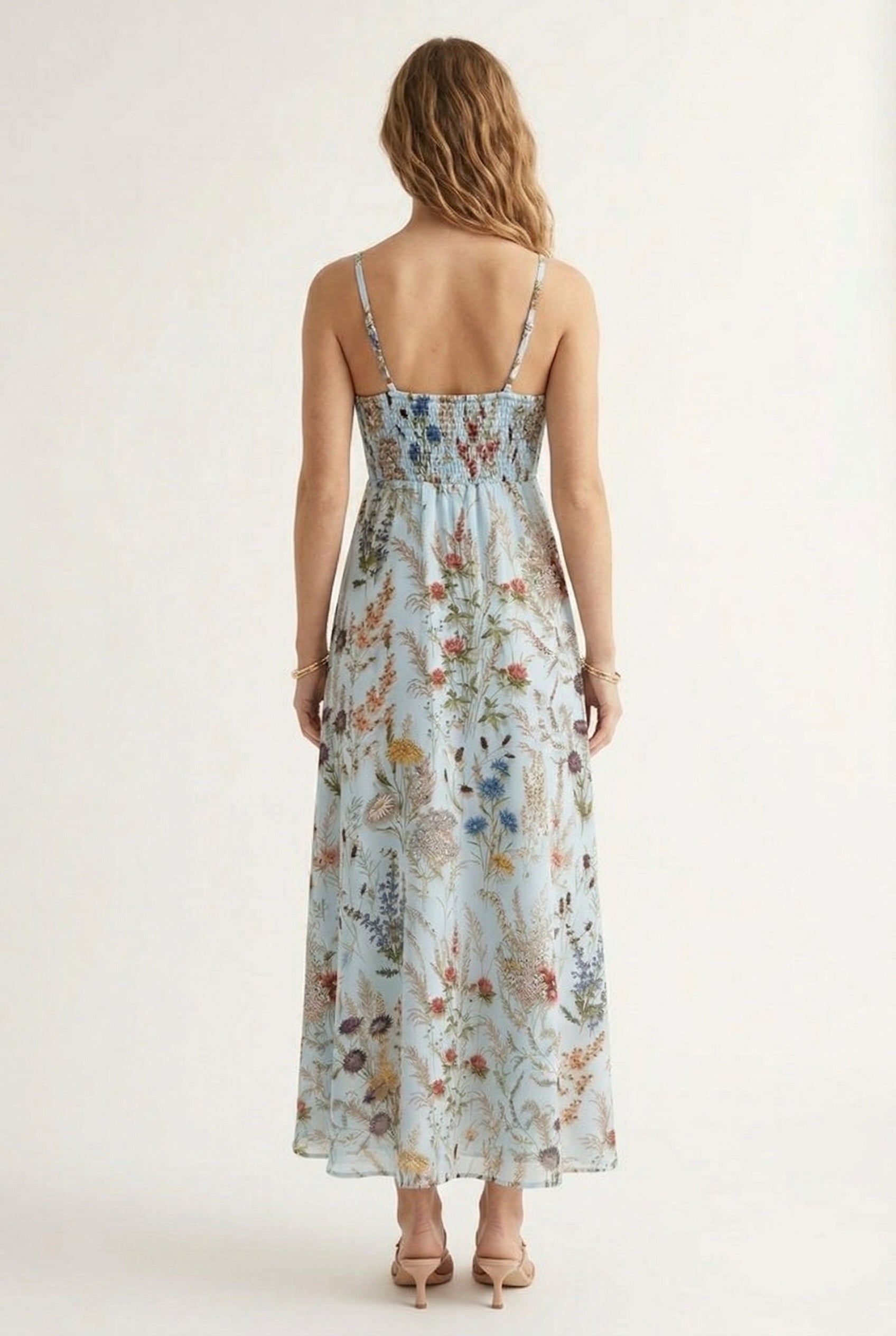 Woman wearing a chambray blue floral print maxi dress with spaghetti straps