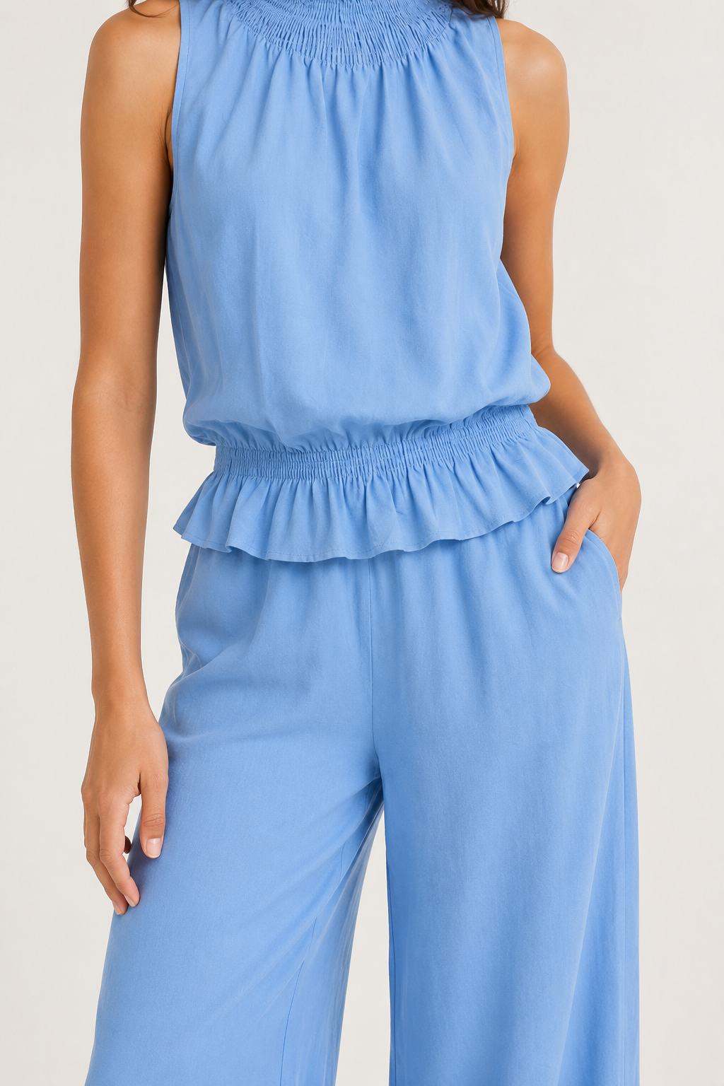 Woman wearing a premium minimalist chambray blue two piece set with sleeveless top and wide leg pants