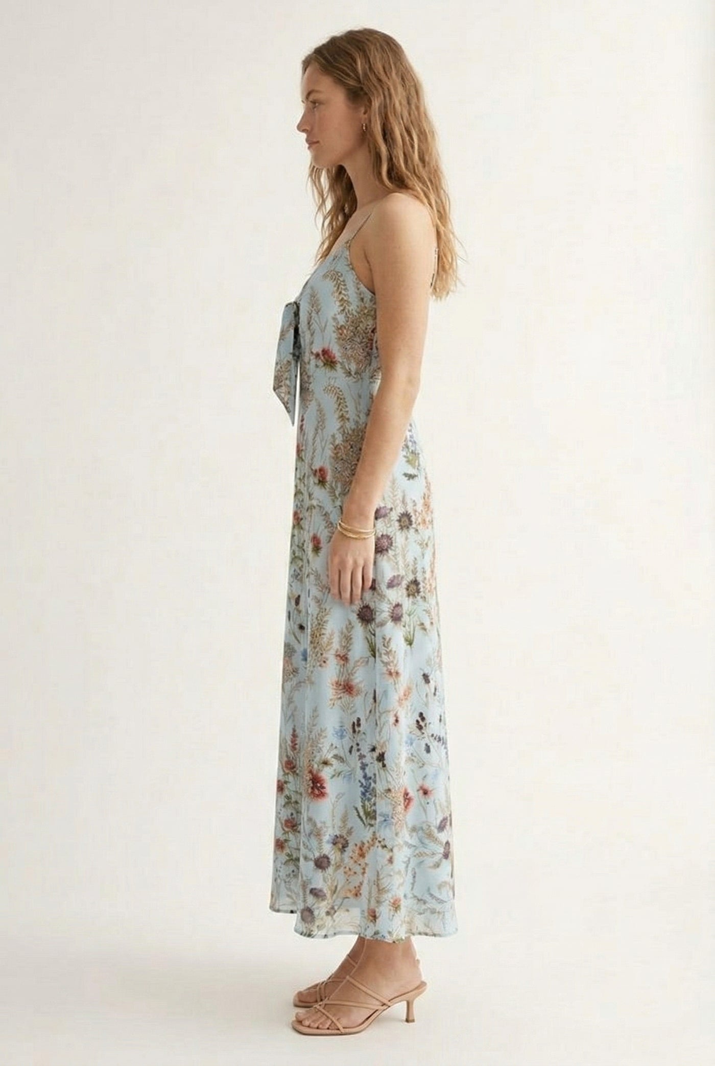 Woman wearing a chambray blue floral print maxi dress with spaghetti straps