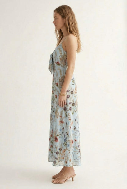 Woman wearing a chambray blue floral print maxi dress with spaghetti straps