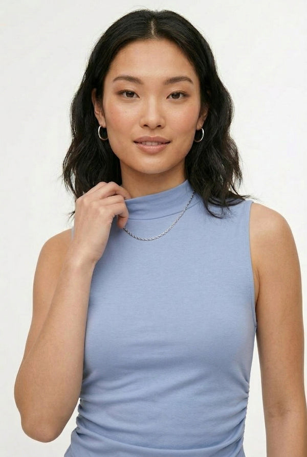 Woman wearing a soft cloud blue sleeveless jumpsuit featuring wide-cut legs.