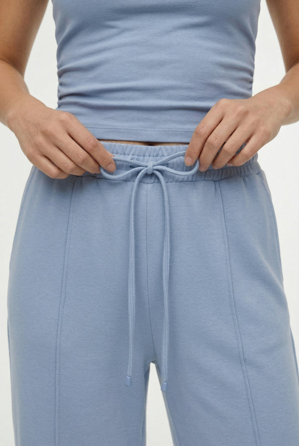 Woman wearing a soft cloud blue sleeveless jumpsuit featuring wide-cut legs.