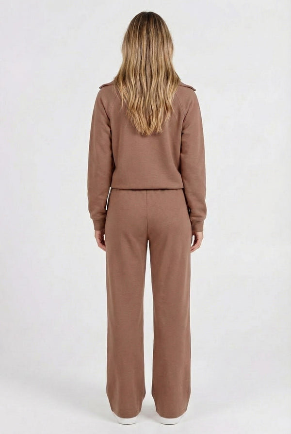 Woman wearing the LOHNR Élan Set in Cocoa Bean, featuring a smooth, sweatshirt-material half-zip pullover and matching structured pants.