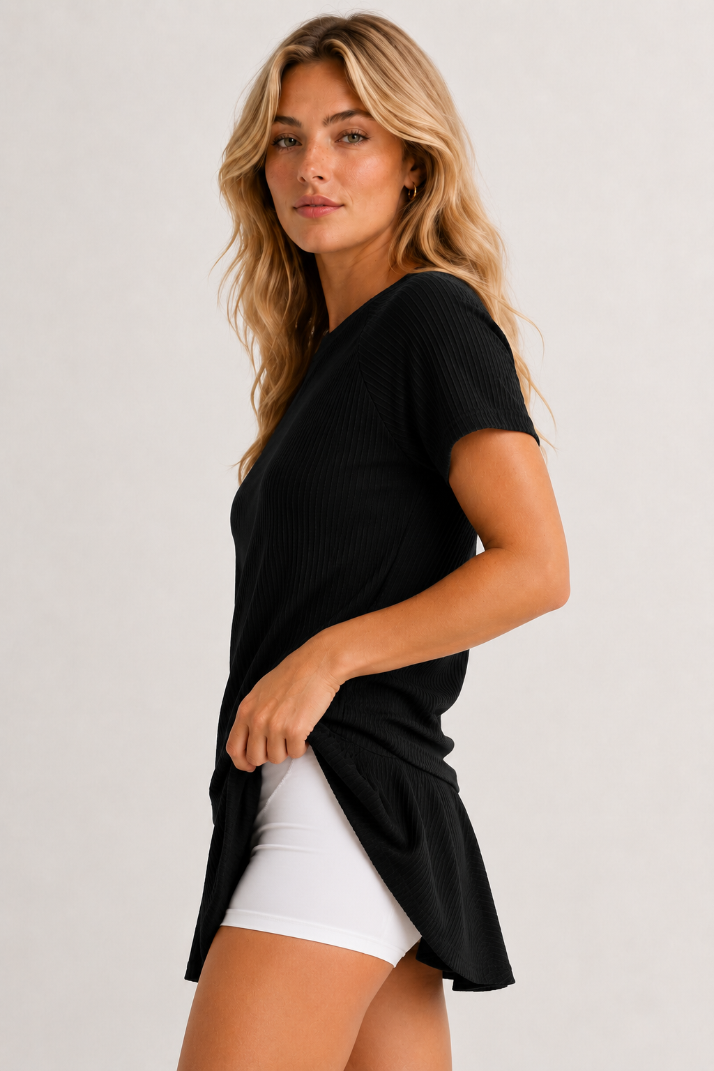 Woman wearing an onyx black short sleeve top and matching mini skirt lounge set.