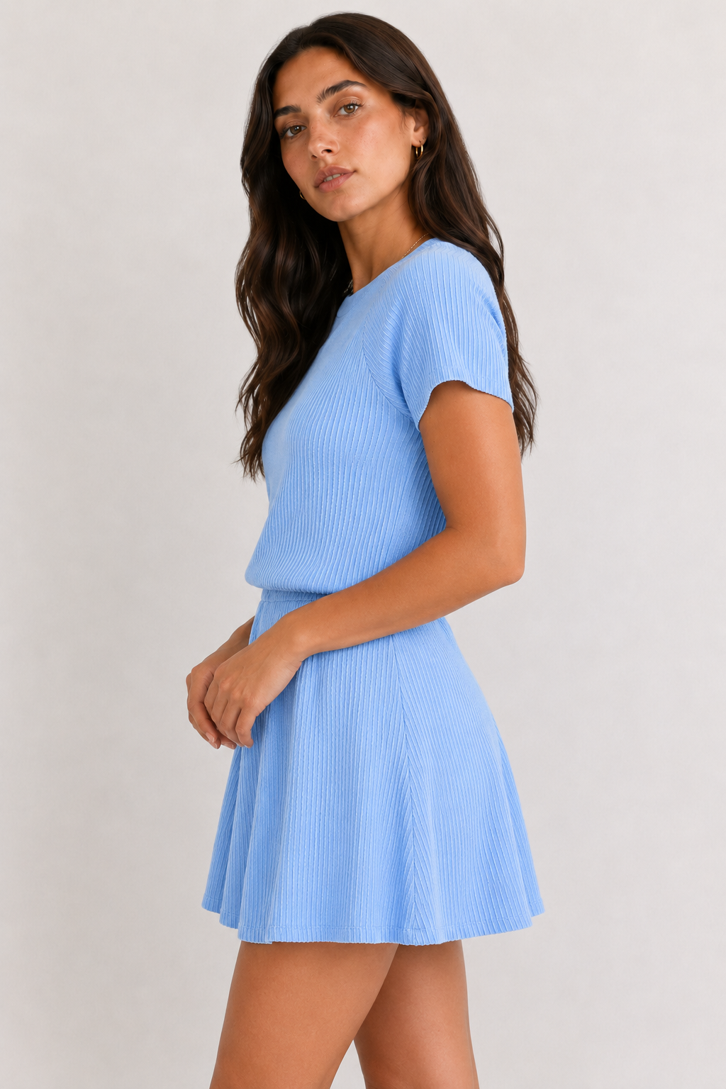 Woman wearing a powder blue short sleeve top and matching mini skirt lounge set.
