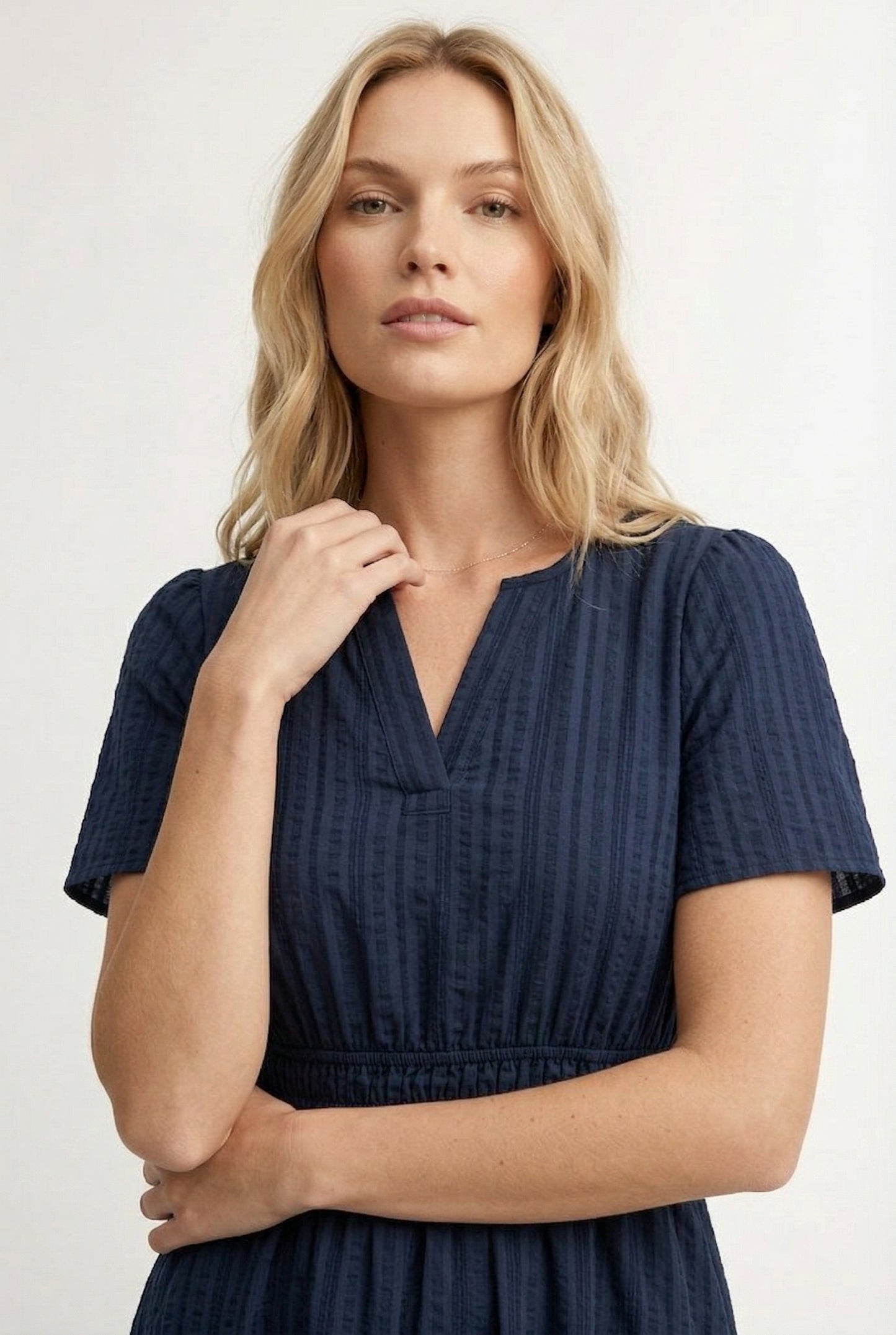 Woman wearing a short sleeve v-neck tiered dress in total eclipse navy blue