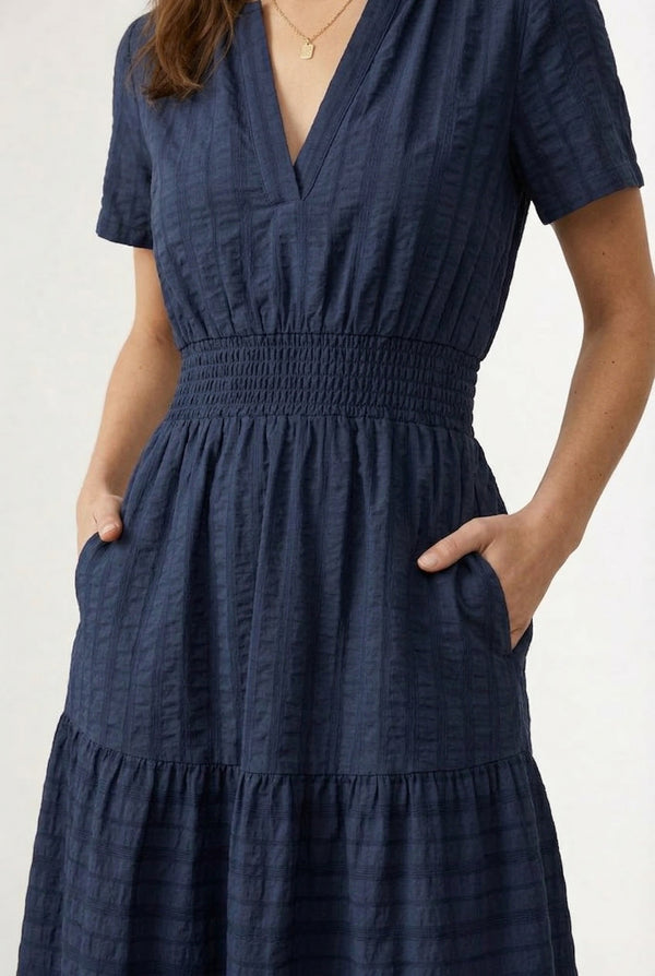 A woman wearing a dark navy Total Eclipse short-sleeve midi dress with a button-down front.