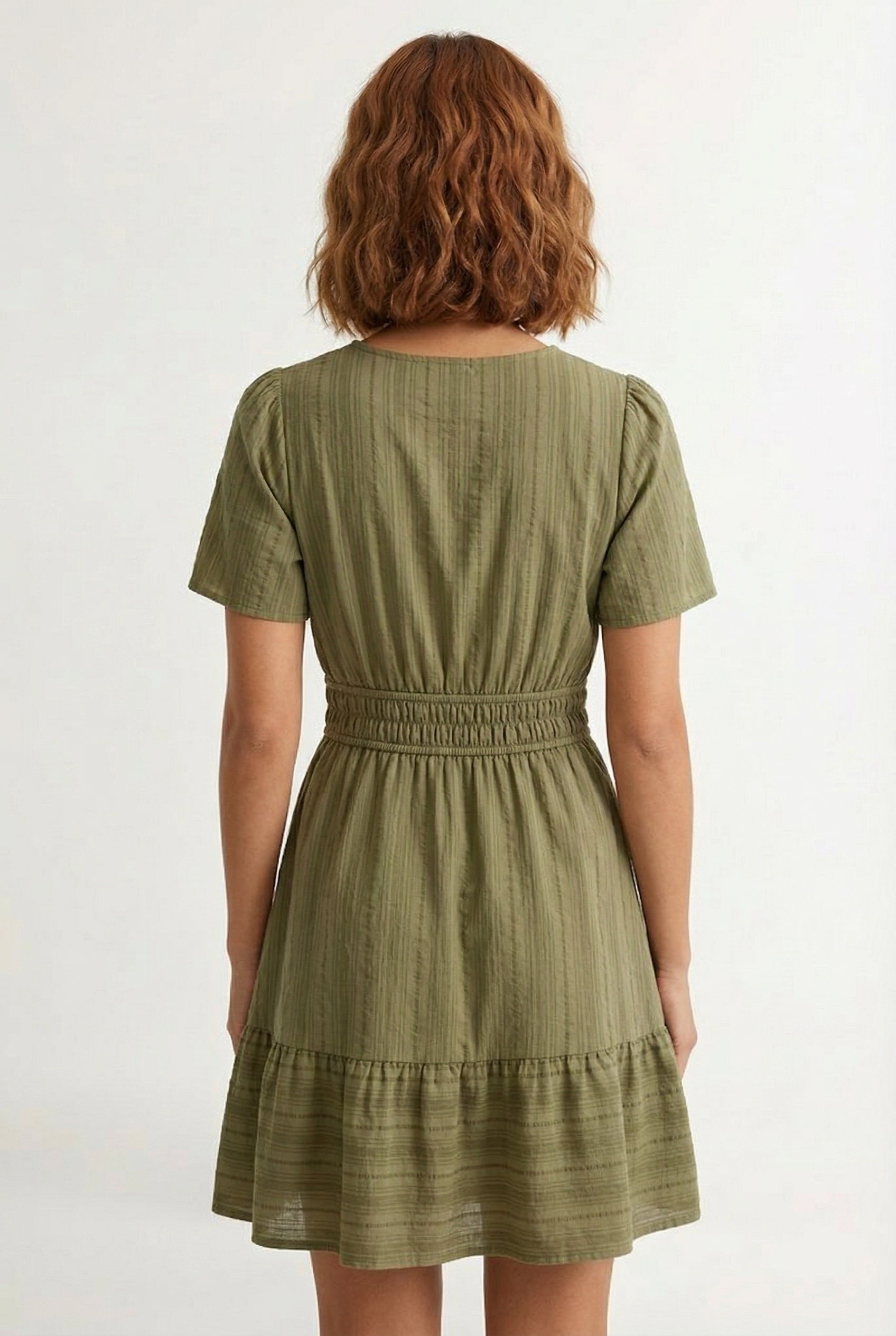Woman wearing a short sleeve v-neck tiered dress in dark olive green