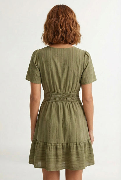 Woman wearing a short sleeve v-neck tiered dress in dark olive green