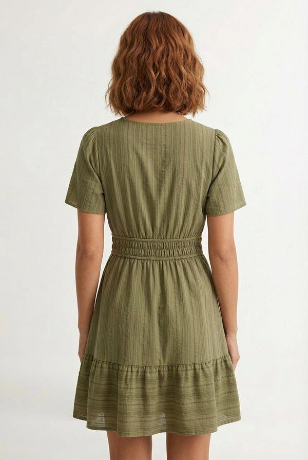 Woman wearing a short sleeve v-neck tiered dress in dark olive green