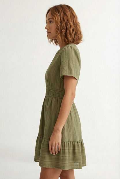 Woman wearing a short sleeve v-neck tiered dress in dark olive green