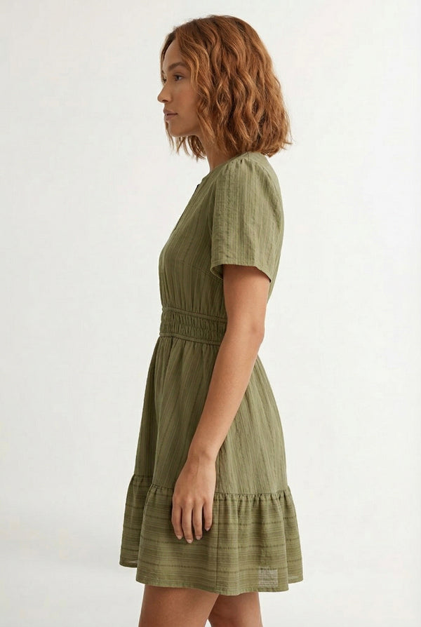 Woman wearing a short sleeve v-neck tiered dress in dark olive green