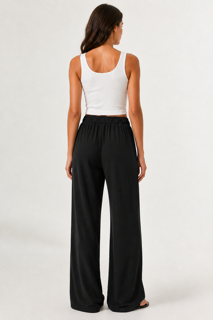 Woman modeling premium high-waisted wide-leg pants in black Onyx against a clean studio background