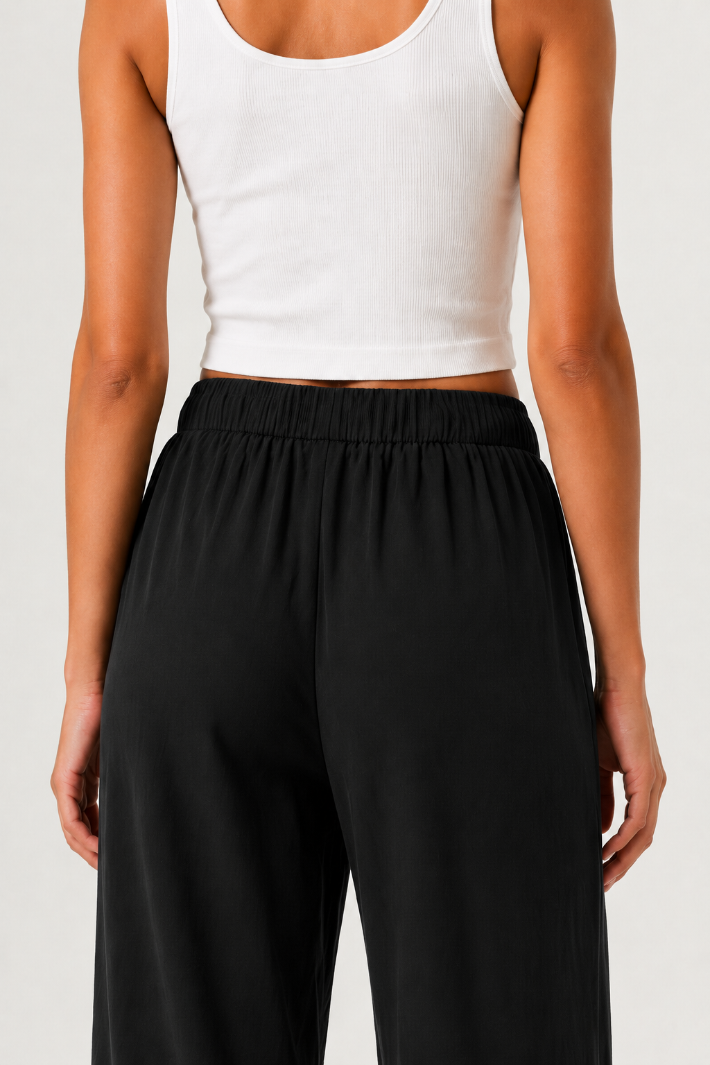 Woman modeling premium high-waisted wide-leg pants in black Onyx against a clean studio background
