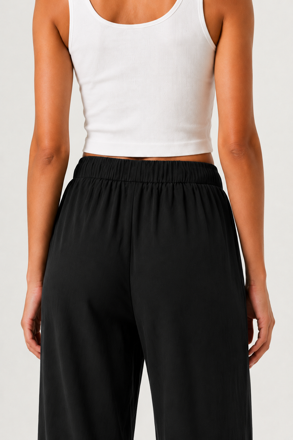 Woman modeling premium high-waisted wide-leg pants in black Onyx against a clean studio background