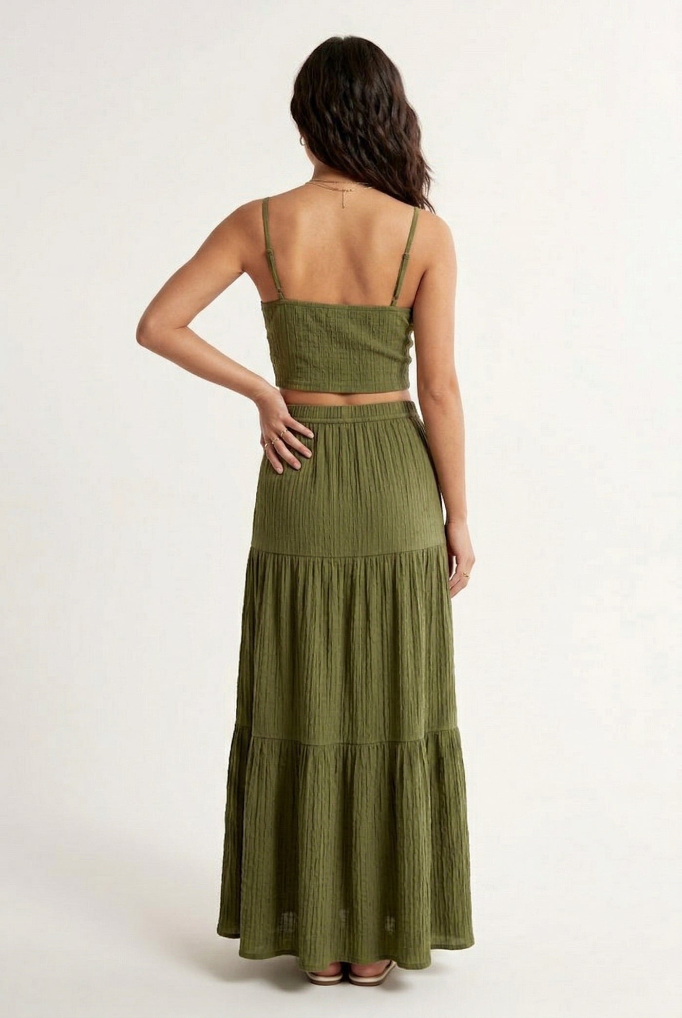 Woman modeling a Fatigue Green two-piece matching set featuring a spaghetti strap crop top and tiered maxi skirt