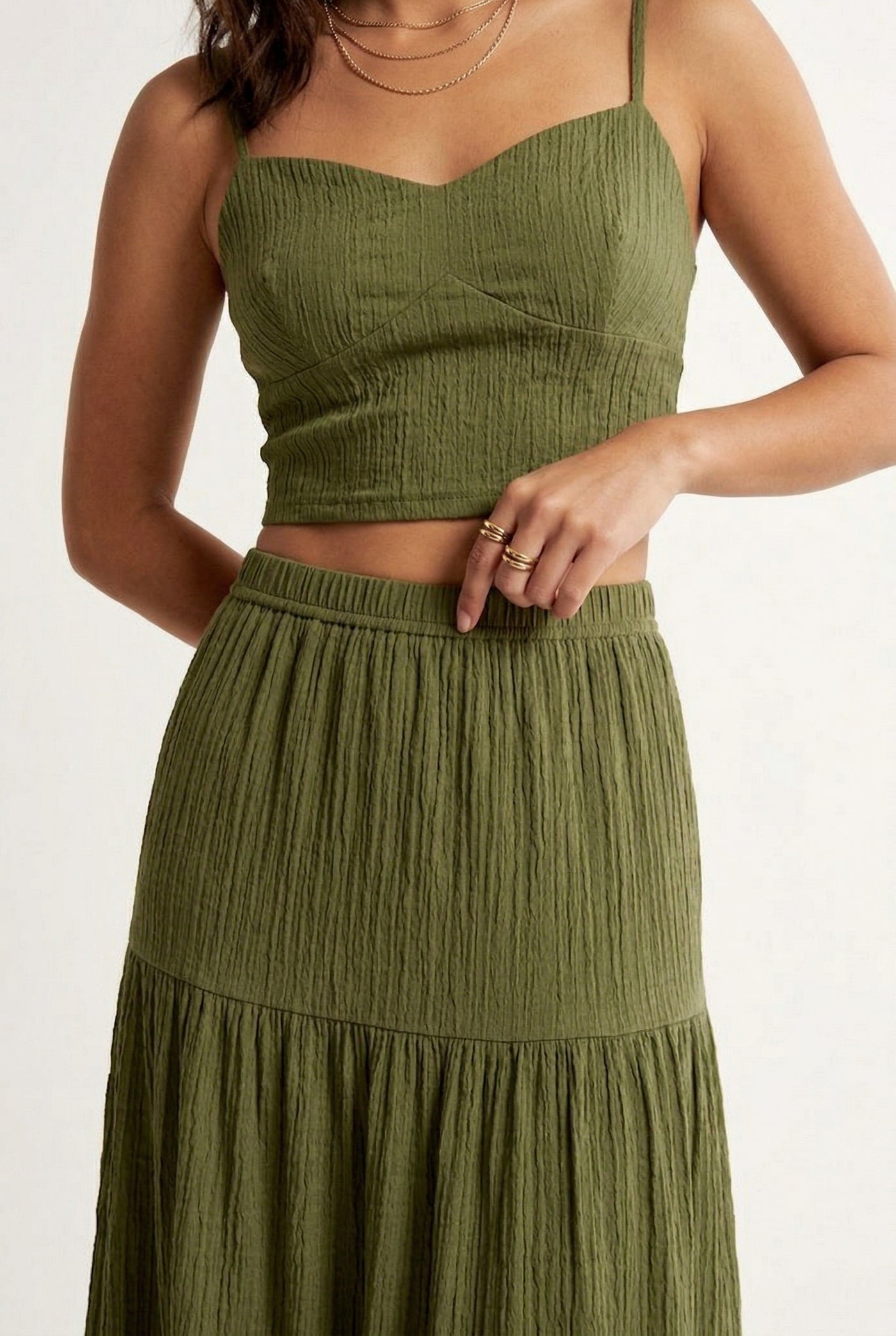 Woman modeling a Fatigue Green two-piece matching set featuring a spaghetti strap crop top and tiered maxi skirt