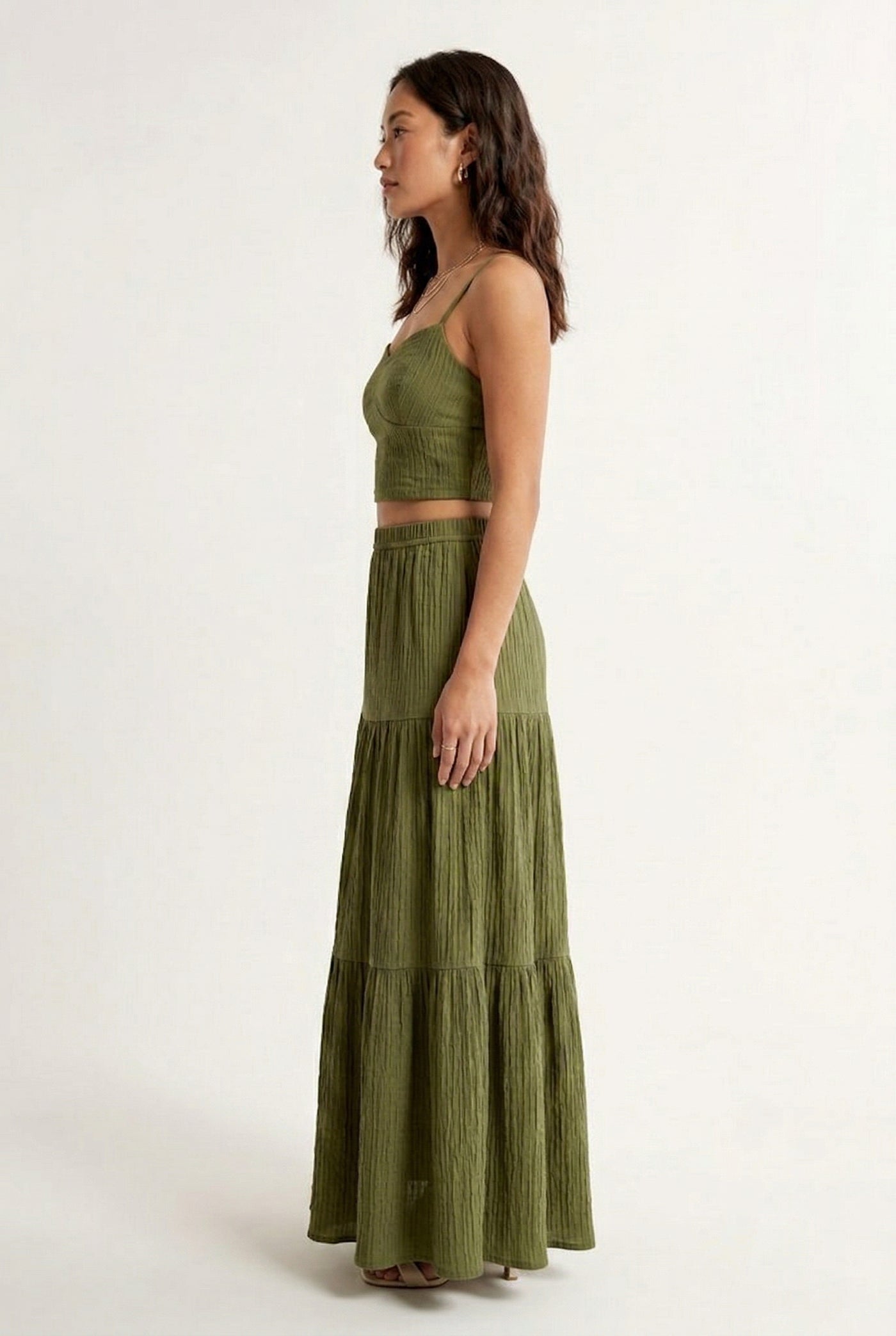 Woman modeling a Fatigue Green two-piece matching set featuring a spaghetti strap crop top and tiered maxi skirt