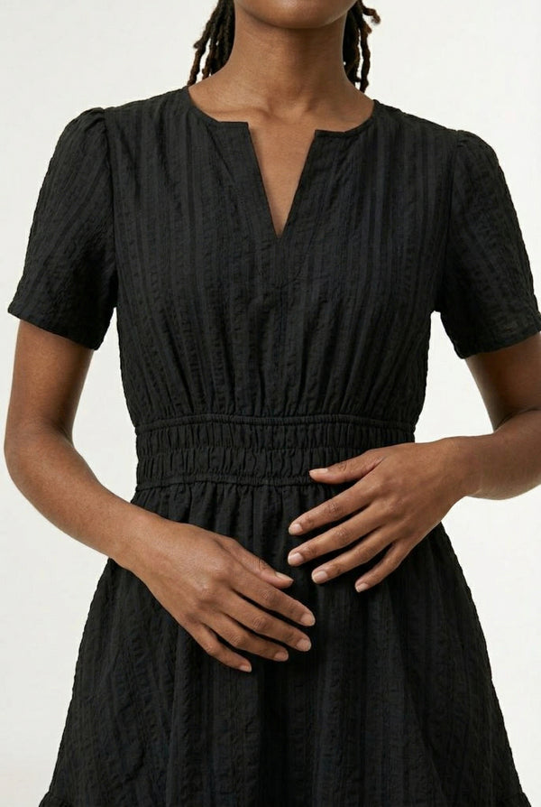 Woman wearing a short sleeve v-neck tiered dress in onyx black