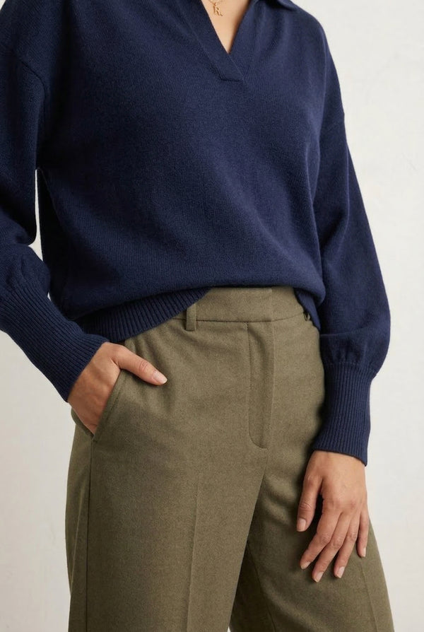 Woman wearing the LOHNR Amélie Collared Sweater in deep indigo, featuring a relaxed V-neck and structured polo collar.