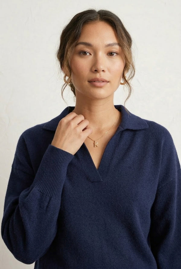 Woman wearing the LOHNR Amélie Collared Sweater in deep indigo, featuring a relaxed V-neck and structured polo collar.