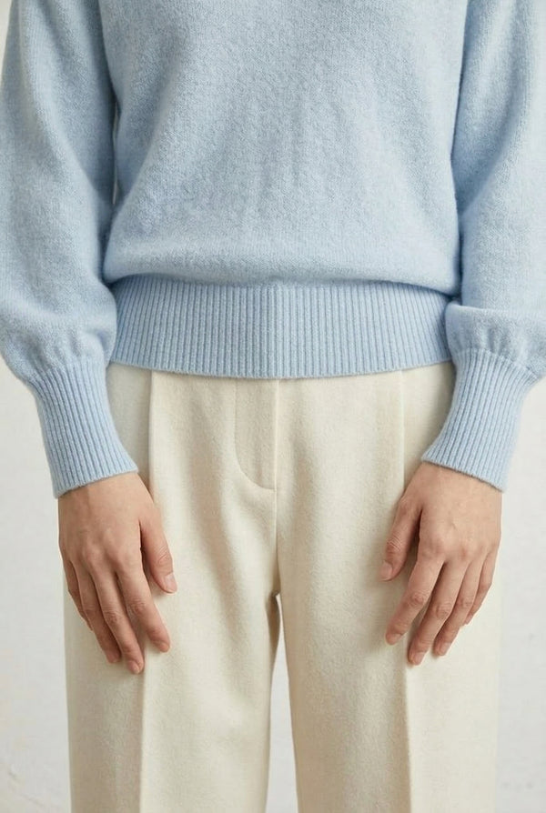 Woman wearing the LOHNR Amélie Collared Sweater in iced aqua, featuring a relaxed V-neck and structured polo collar.