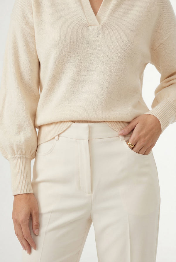 Woman wearing the LOHNR Amélie Collared Sweater in light birch, featuring a relaxed V-neck and structured polo collar.