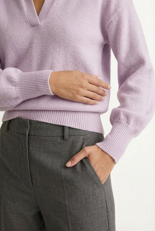 Woman wearing the LOHNR Amélie Collared Sweater in soft lavandin, featuring a relaxed V-neck and structured polo collar.