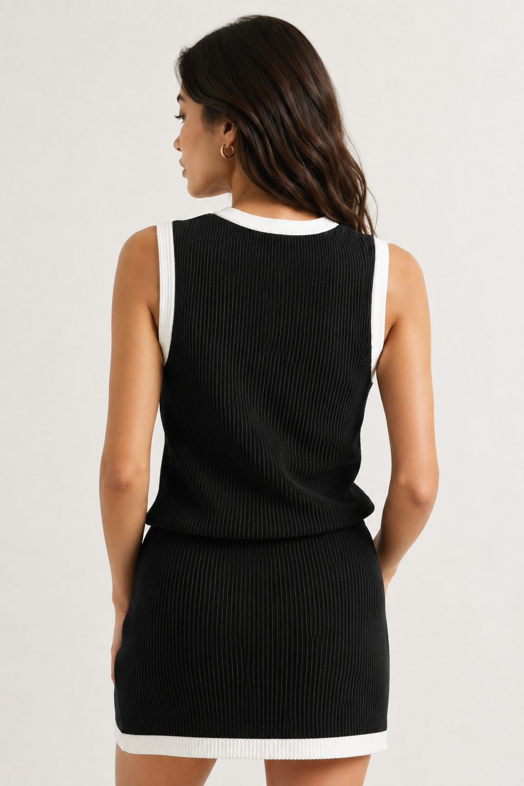 LOHNR Bound Rib Set in Onyx. A structured black sleeveless knit top and matching asymmetric skirt, finished with precision contrast white binding.