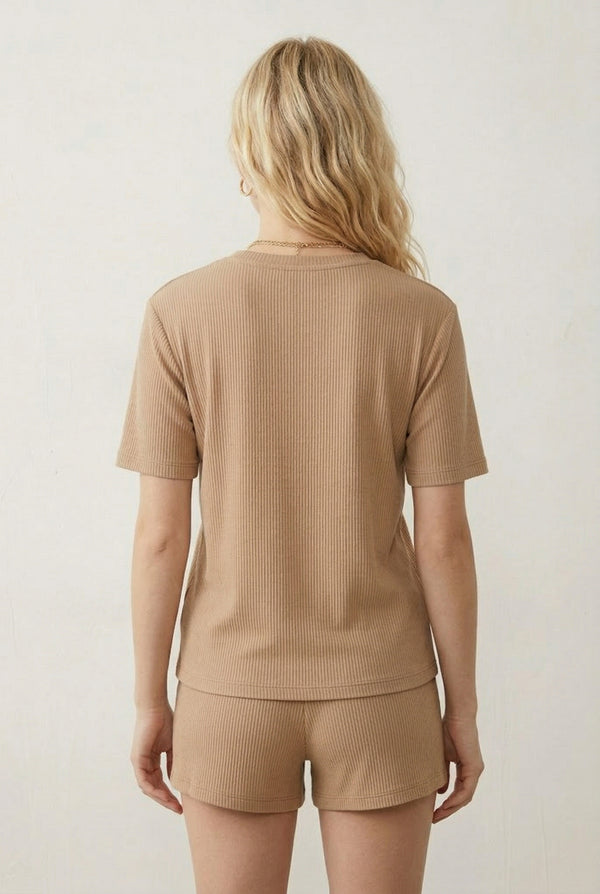Woman modeling the LOHNR Celine Rib Set in Dune, an elevated ribbed t-shirt and short loungewear set