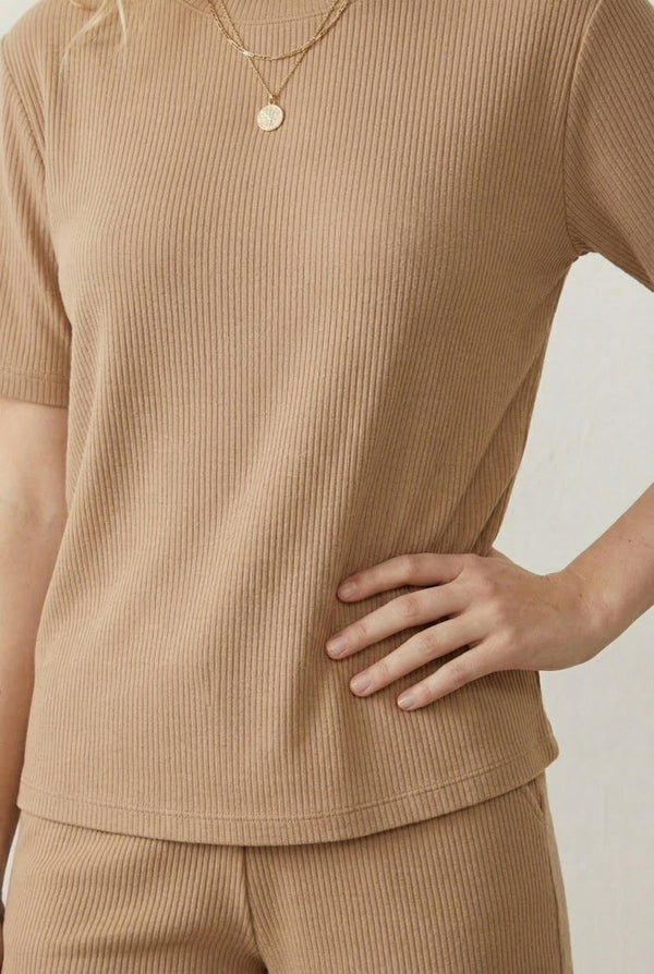 Woman modeling the LOHNR Celine Rib Set in Dune, an elevated ribbed t-shirt and short loungewear set