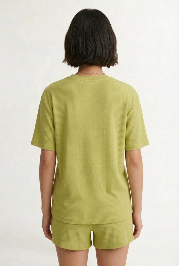 Woman modeling the LOHNR Celine Rib Set in Lemongrass, an elevated ribbed t-shirt and short loungewear set
