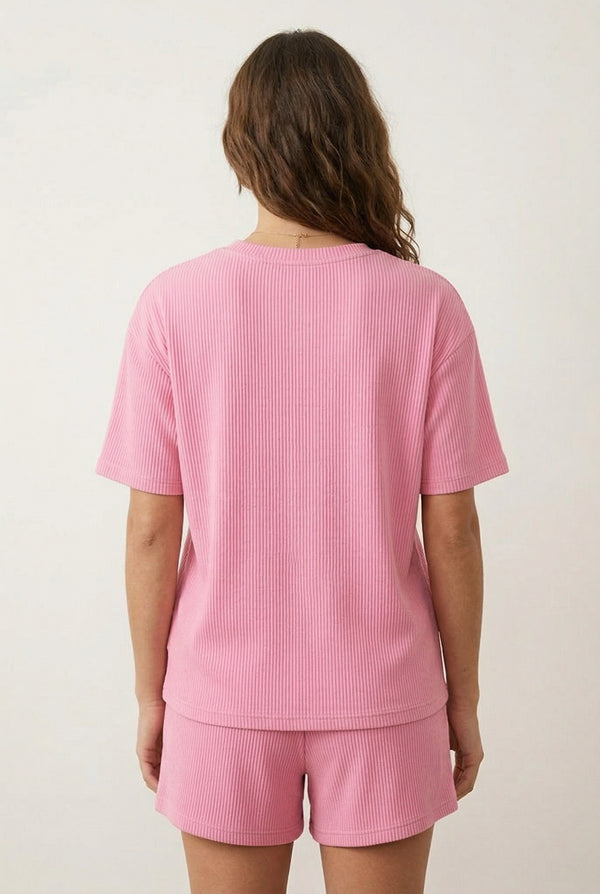 Woman modeling the LOHNR Celine Rib Set in Peony, an elevated ribbed t-shirt and short loungewear set