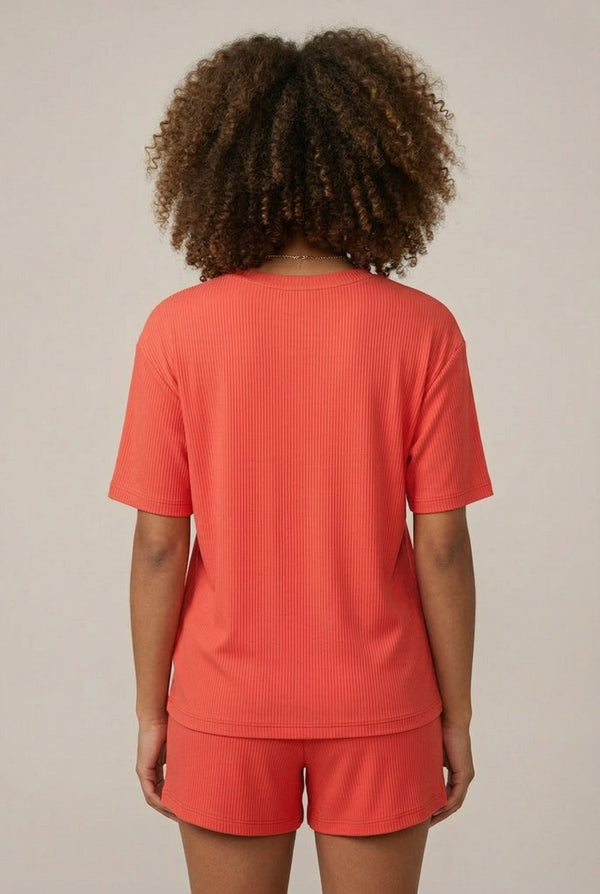 Woman modeling the LOHNR Celine Rib Set in Poppy, an elevated ribbed t-shirt and short loungewear set