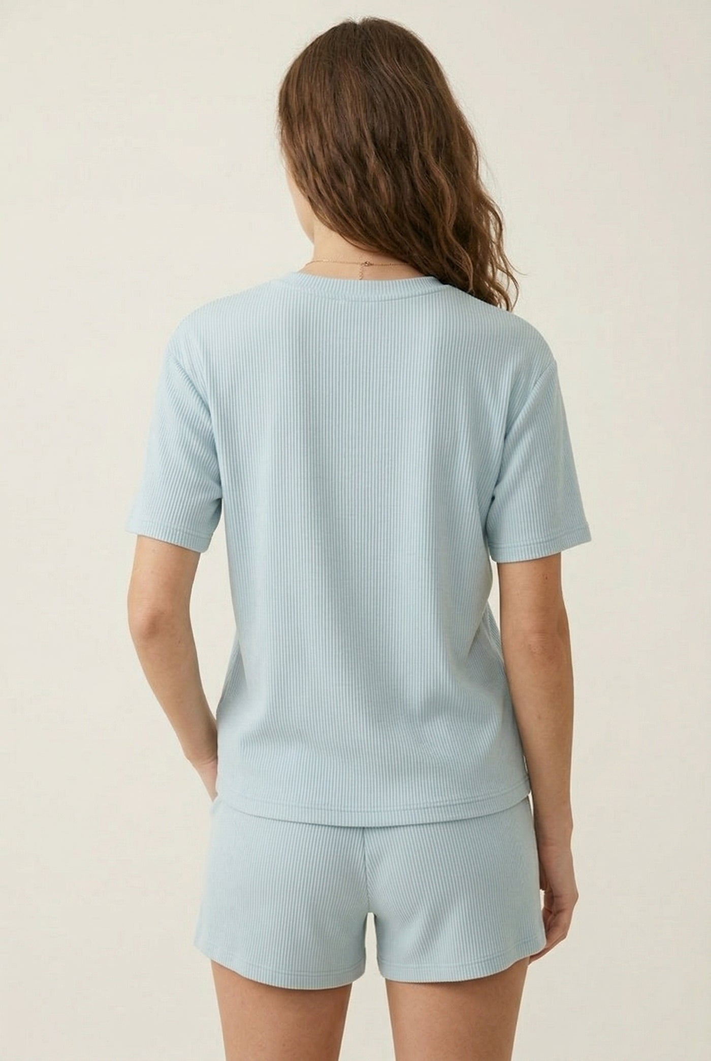 Woman modeling the LOHNR Celine Rib Set in Powder Blue, an elevated ribbed t-shirt and short loungewear set