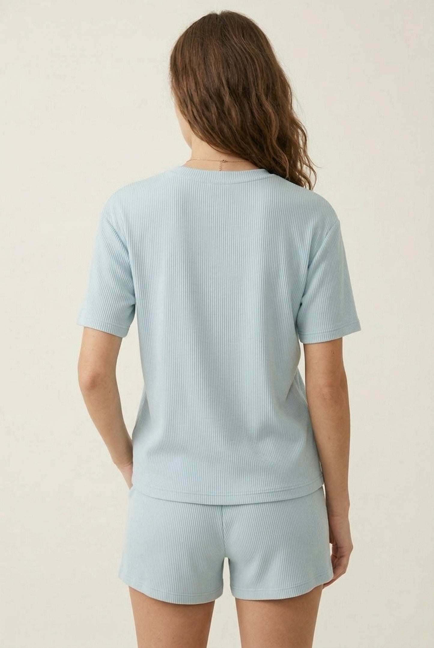 Woman modeling the LOHNR Celine Rib Set in Powder Blue, an elevated ribbed t-shirt and short loungewear set