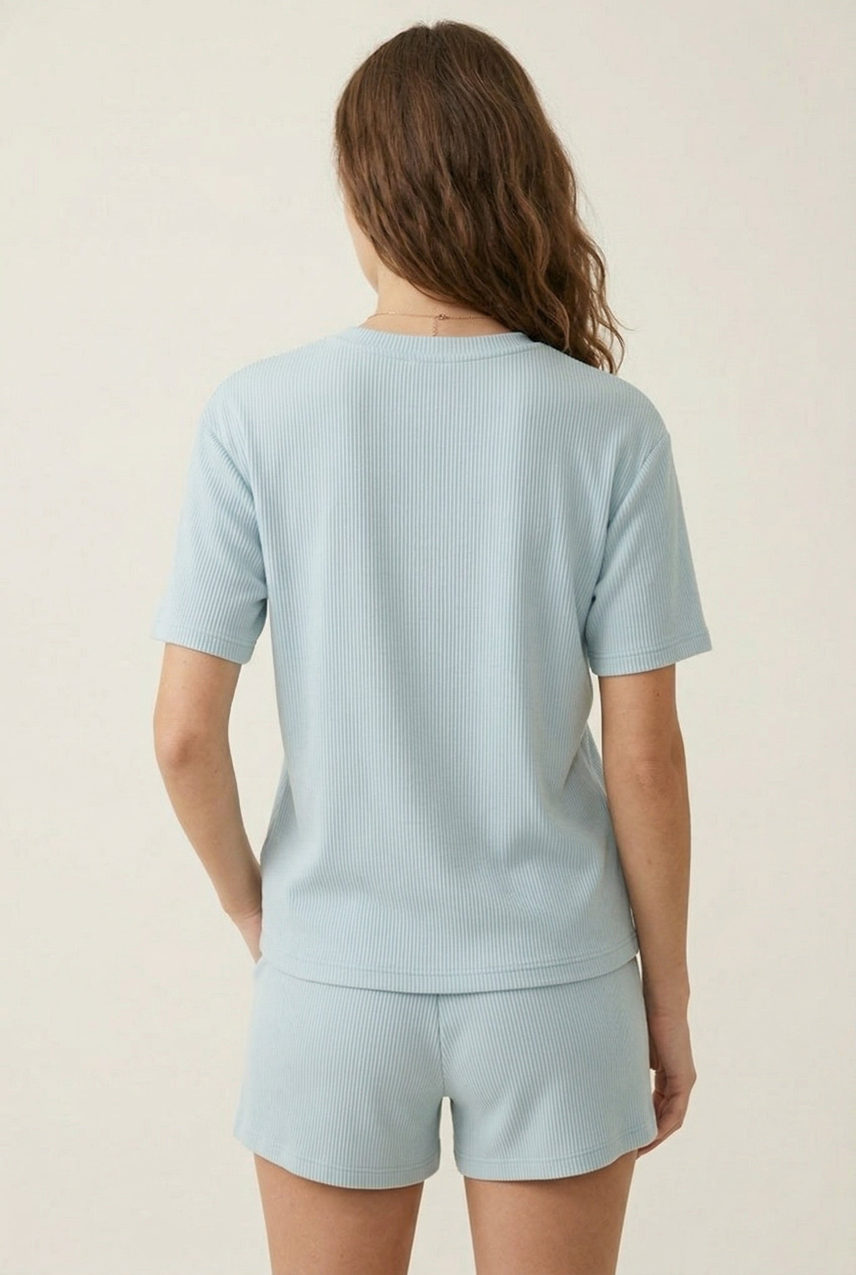 Woman modeling the LOHNR Celine Rib Set in Powder Blue, an elevated ribbed t-shirt and short loungewear set