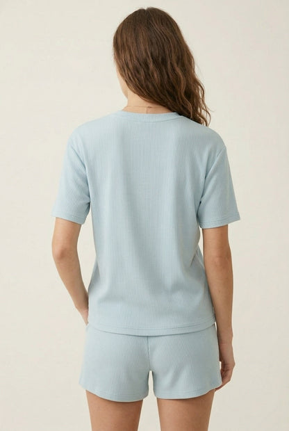 Woman modeling the LOHNR Celine Rib Set in Powder Blue, an elevated ribbed t-shirt and short loungewear set