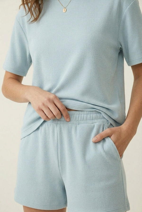 Woman modeling the LOHNR Celine Rib Set in Powder Blue, an elevated ribbed t-shirt and short loungewear set