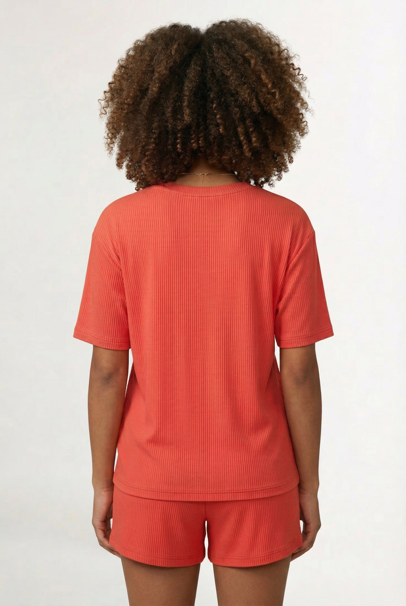 Woman modeling the LOHNR Celine Rib Set in Poppy, an elevated ribbed t-shirt and short loungewear set