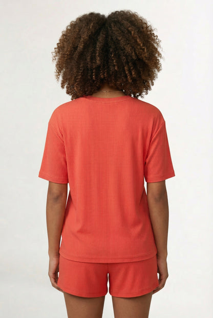 Woman modeling the LOHNR Celine Rib Set in Poppy, an elevated ribbed t-shirt and short loungewear set