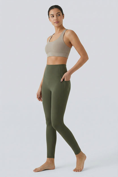 Women's high-waisted Contour Pocket Legging in Alpine green, featuring a seamless front, hidden side pockets, and body-contouring compression fit.