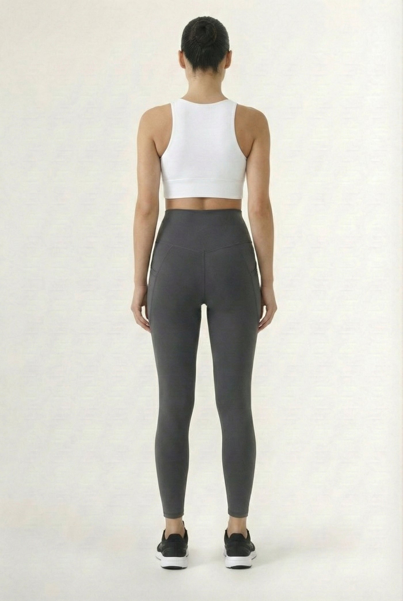 Women's high-waisted Contour Pocket Legging in Asphalt grey, featuring a seamless front, hidden side pockets, and body-contouring compression fit.