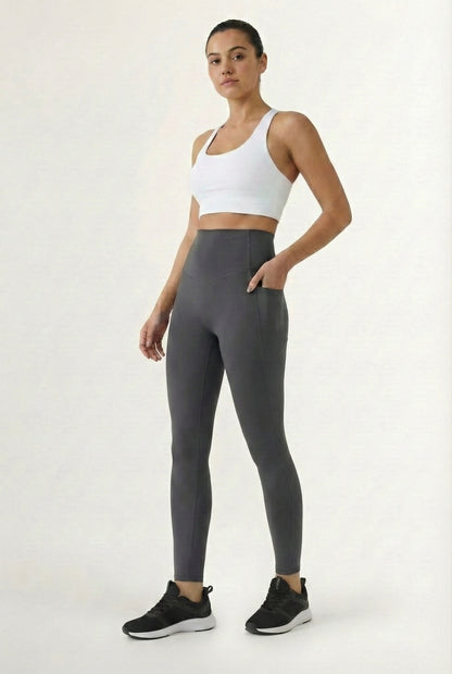 Women's high-waisted Contour Pocket Legging in Asphalt grey, featuring a seamless front, hidden side pockets, and body-contouring compression fit.